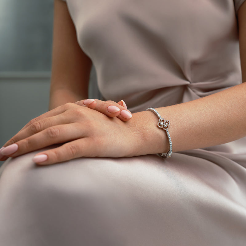 Be Boodles pink and white diamond bangle in platinum and rose gold worn by a woman.