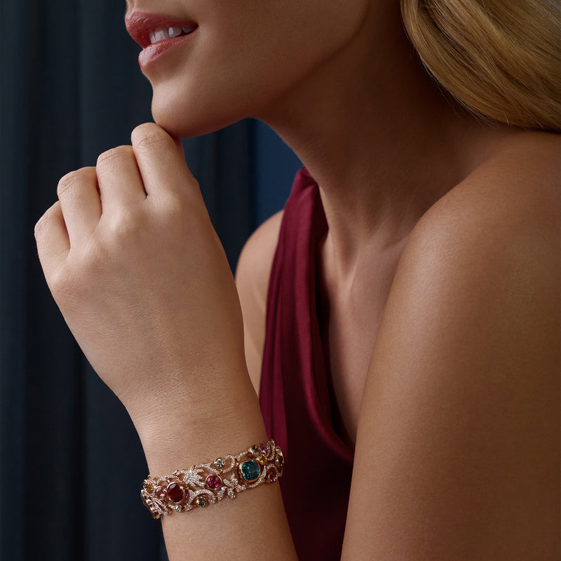The Palace Collection Royal Damask rose gold bracelet worn by a model, featuring blue zircons, pink tourmalines, sapphires, and diamonds.
