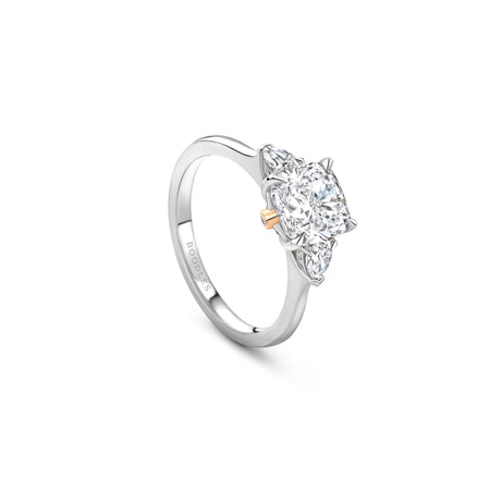 Boodles Peace of Mined Petal platinum engagement ring featuring a cushion-cut center diamond and pear-shaped side stones.