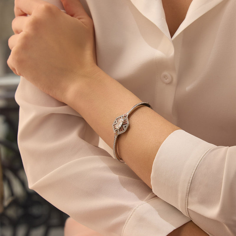 Fifth Avenue Ashoka Diamond Platinum Bangle worn on a model's wrist, featuring pink enamel and an Ashoka cut diamond.