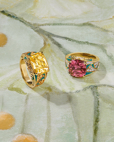 Two gold Boodles jewellery rings with large colour gemstones, enamel and diamonds on a floral-patterned background