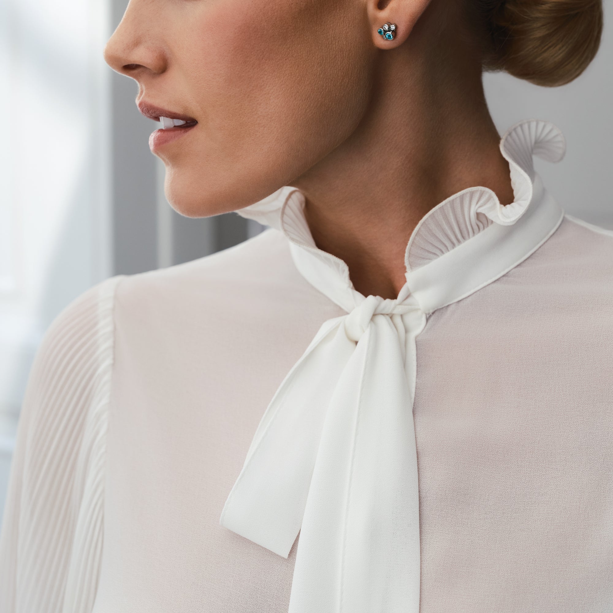 Raindance Paraiba tourmaline and diamond platinum cluster earrings worn by a woman.