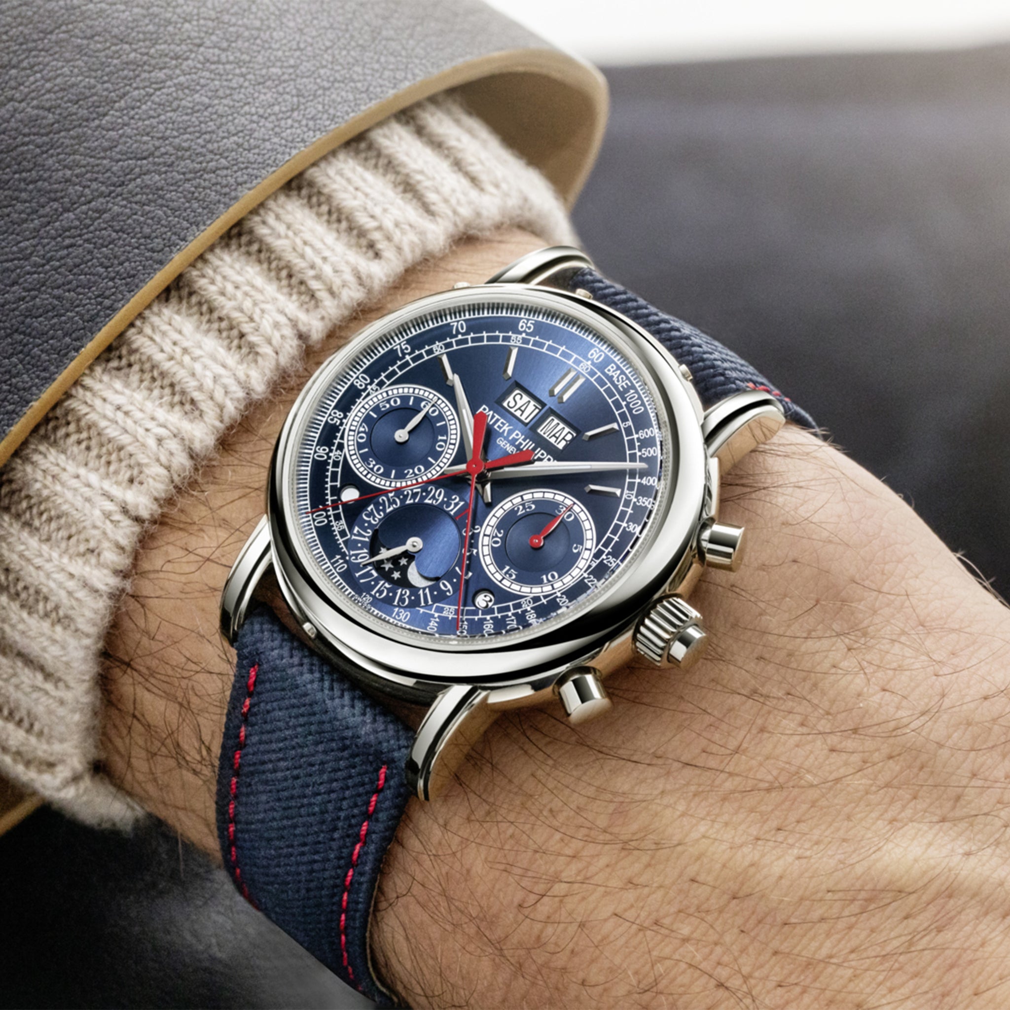Patek Philippe Ref. 5204G-010 white gold watch with a sunburst navy blue dial and strap, worn on the wrist.