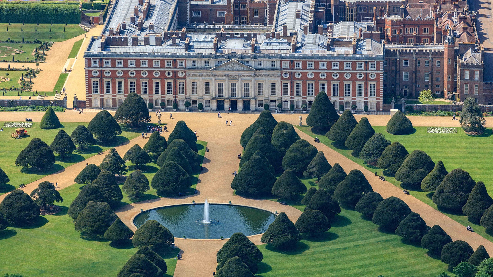 Aerial view of a large historic building with a formal garden and pond. Historic Royal Palaces, Chelsea flower show, Boodles garden.