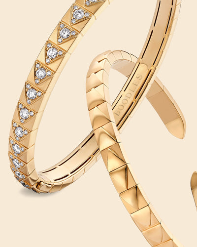 Boodles Be You bangles in single mine origin gold set with round diamonds on a beige background