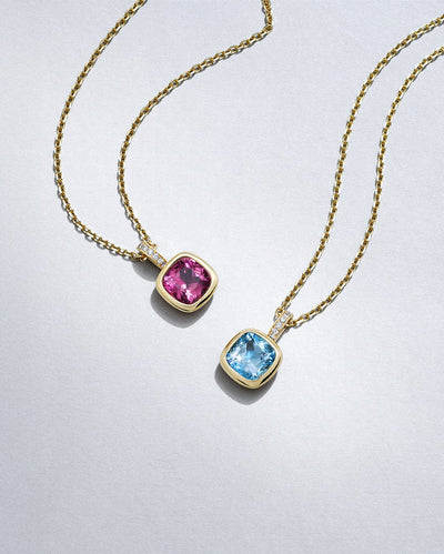 Two gold Florentine necklaces with colourful gemstones and diamonds by Boodles on a light grey background