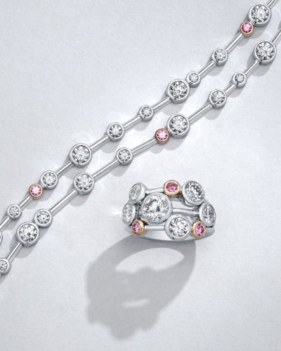Boodles platinum Riandance necklace and ring with round briliiant pink diamonds on a light grey background